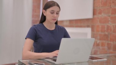 Laptop 'ta çalışan genç Latin Kadın Kameraya doğru bakıyor