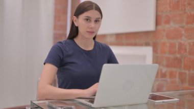 Laptop 'ta çalışırken Genç Latin Kadın Parmak Gösteriyor