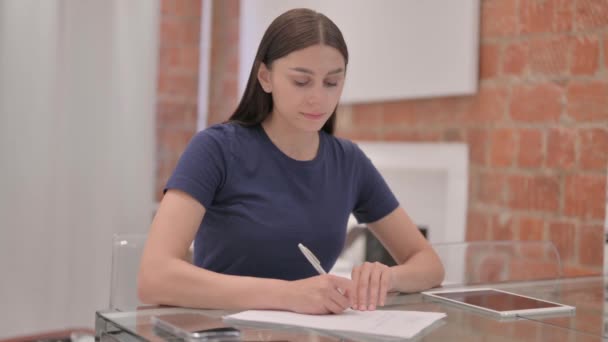 Junge Latina Frau Schreibt Während Sie Papierkram Erledigt — Stockvideo
