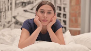 Ciddi Genç Latin Kadın Yatakta Mide Uzanıp Kameraya Bakıyor