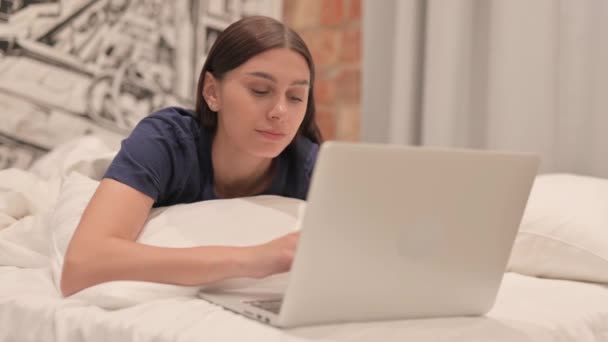Junge Latina Arbeitet Laptop Während Sie Bett Auf Dem Bauch — Stockvideo