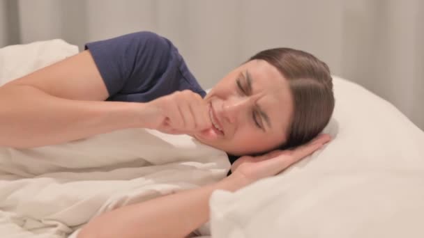 横にベッドに寝そべっている若いラティーナの女性を咳 — ストック動画