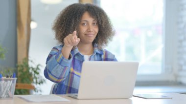 Genç Afrikalı Kadın Dizüstü bilgisayarla çalışırken kamerayı işaret ediyor