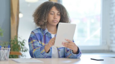 Tablet bilgisayar kullanan neşeli genç Afrika kadın