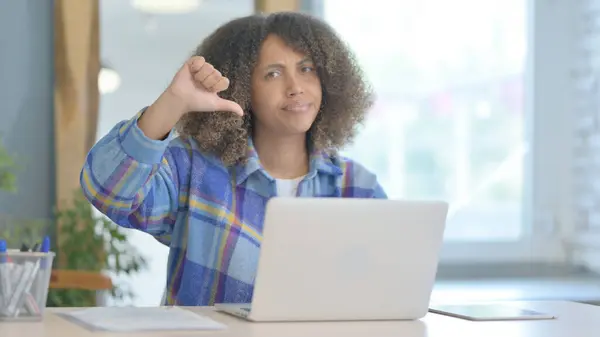 在笔记本电脑上工作的非洲年轻妇女的拇指按下 — 图库照片