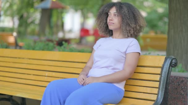 Ernste Junge Afrikanerin Sitzt Draußen — Stockvideo