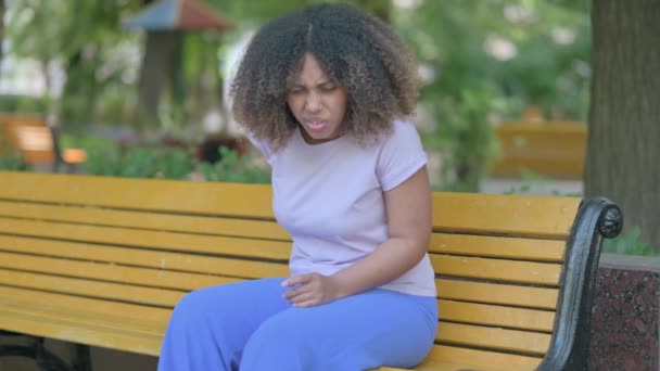 非洲青年妇女坐在户外背痛 — 图库视频影像