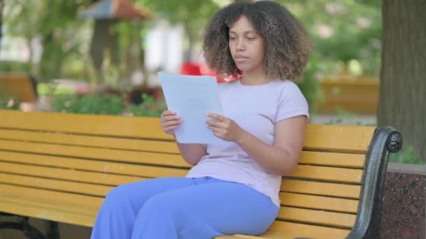 非洲青年妇女在室外阅读合同时感到沮丧 — 图库视频影像