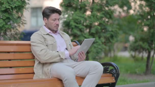 Hombre Mediana Edad Usando Tablet Mientras Está Sentado Aire Libre — Vídeos de Stock