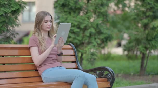 坐在户外长椅上使用平板电脑的年轻女性 — 图库视频影像
