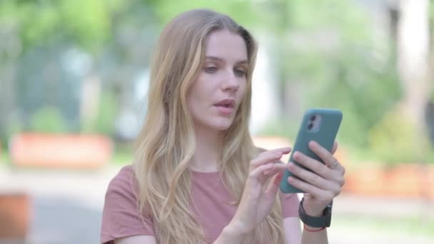 惊慌失措的年轻女子在智能手机上的户外肖像 — 图库视频影像