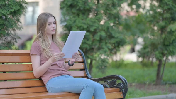 stock image Young Woman Reading Documents while Sitting Outdoor on a Bench