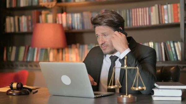 Male Lawyer Talking on Phone with Client at work