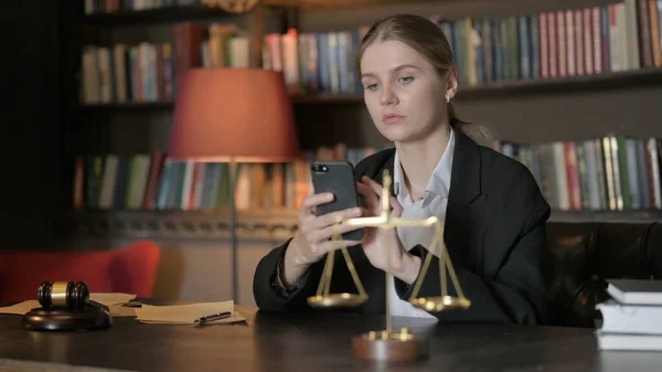 オフィスでスマートフォンを使った女性弁護士 — ストック写真