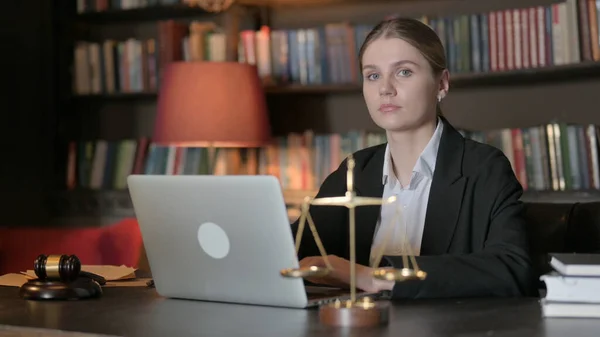 ラップトップで作業しながらカメラを見ている真剣な女性弁護士 — ストック写真