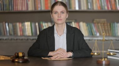 Dizüstü bilgisayarda çalışırken kameraya bakan Ciddi Erkek Avukat