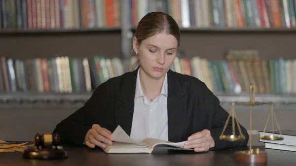 Female Lawyer Reading Law Book in Office