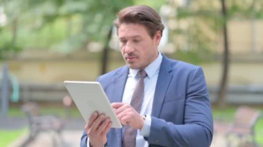 Ofisin dışında ayakta dururken Tablet kullanan İşadamı