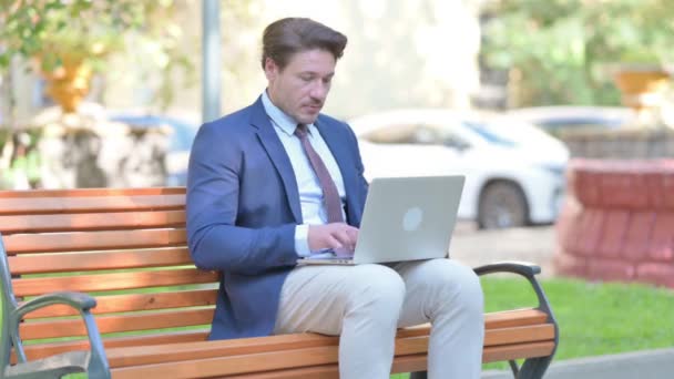Geschäftsmann Schaut Auf Kamera Während Freien Laptop Arbeitet — Stockvideo