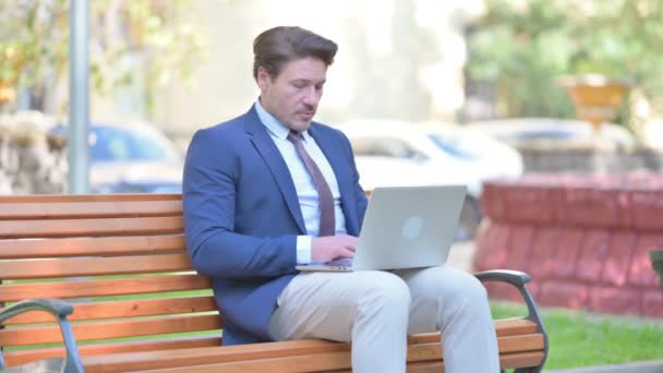 Zmęczony Biznesmen Pozostawiając Ławkę Zewnątrz Zamknięciu Laptopie — Wideo stockowe