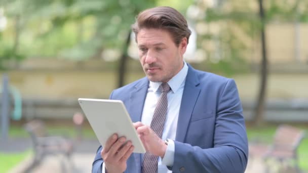 Επιχειρηματίας Γιορτάζοντας Στο Tablet Ενώ Στέκεται Έξω Από Γραφείο — Αρχείο Βίντεο