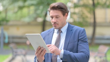 Ofisin dışında ayakta dururken Tablet kullanan İşadamı