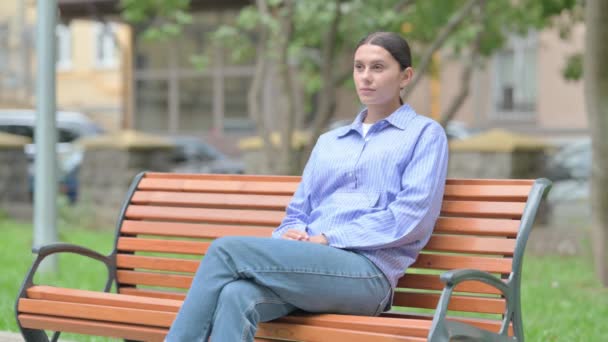 Ernste Hispanische Frau Sitzt Draußen Auf Bank — Stockvideo