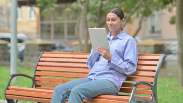 Іспанська Жінка Робить Відео Чат Планшеті Сидячи Відкритому Повітрі Лавці — стокове відео