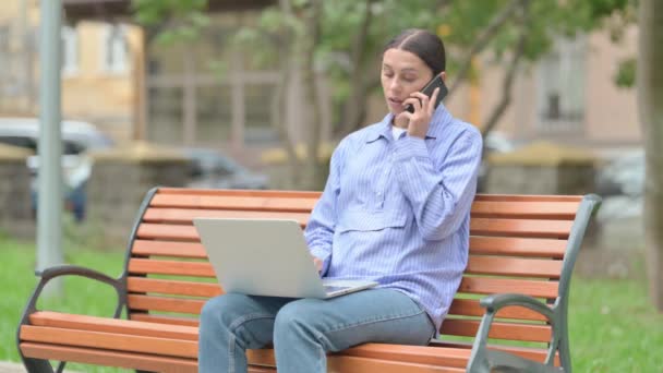 西班牙妇女在电话交谈和使用笔记本电脑室外 — 图库视频影像