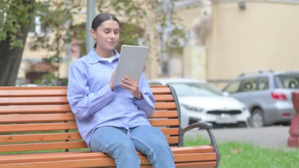 Latynoska Kobieta Świętuje Sukces Tablecie Siedząc Zewnątrz Ławce — Wideo stockowe
