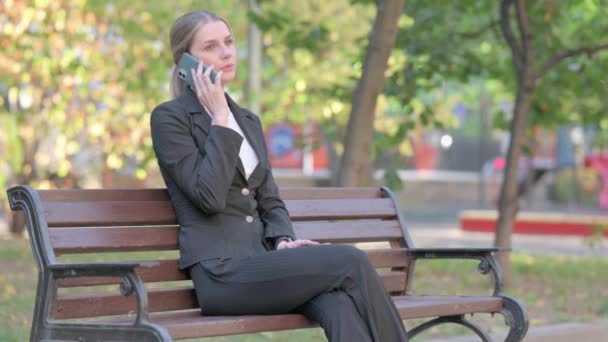Empresaria Hablando Por Teléfono Mientras Está Sentada Aire Libre Banco — Vídeo de stock