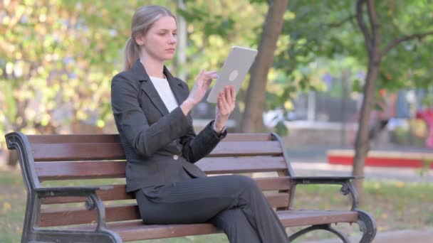 女商人坐在外面的长椅上 一边坐在桌子上一边聊天一边做视频聊天 — 图库视频影像