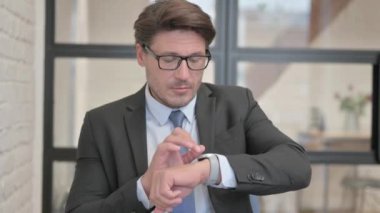 Bekleyen İş Adamı Ofiste Otururken Kol Nöbeti Saati Kontrol Ediyor