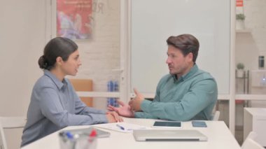 Orta yaşlı adam ofiste yaratıcı Hintli kadınla konuşuyor.
