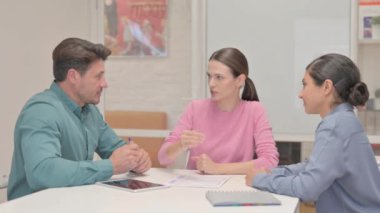 Orta yaşlı adam takım arkadaşlarıyla konuşuyor.