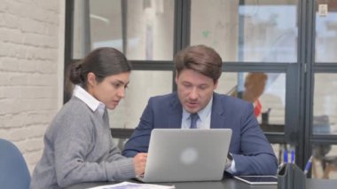 Hintli iş kadını takım arkadaşıyla dizüstü bilgisayarda çalışıyor.