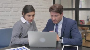 Hintli iş kadını takım arkadaşıyla dizüstü bilgisayarda çalışıyor.