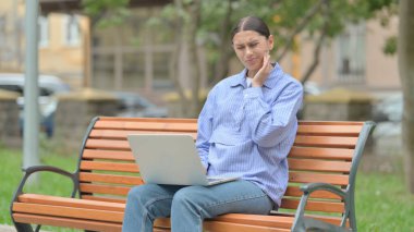 Dişi ağrıyan İspanyol kadın laptopla dışarıda çalışıyor.