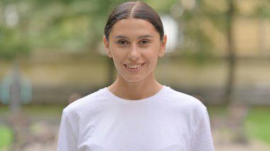 Gülümseyen, kendine güvenen, dışarıda dikilen İspanyol kadın.