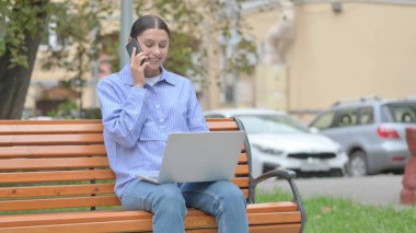 Latin Kadın Telefonda Konuşuyor ve Laptop Kullanıyor