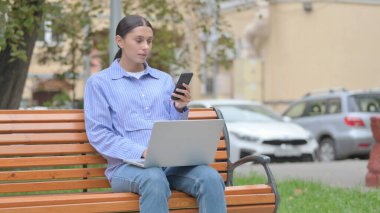 Laptop ve Smartphone kullanan Latin Kadın