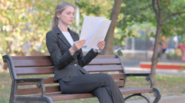 İş kadını Dışarıda Otururken Belgeleri Okurken