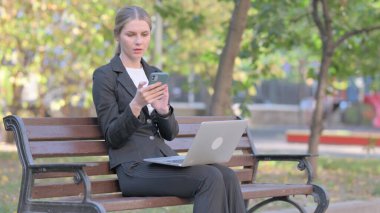 İş kadını Laptop 'ta çalışıyor ve akıllı telefon kullanıyor.