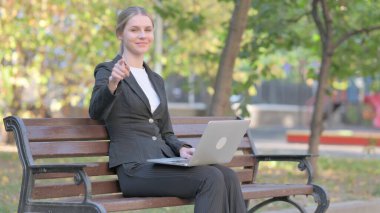 Dizüstü bilgisayar kullanırken kamerayı işaret eden iş kadını hayranlığı