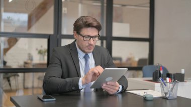 Genç iş kadını bir bankta otururken Tablet kullanıyor.