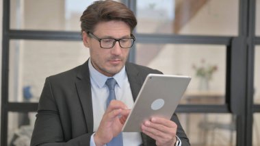 Genç iş kadını bir bankta otururken Tablet kullanıyor.