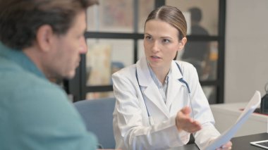 Doctor Discussing Medical Report with Patient in Clinic