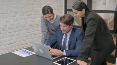 Orta yaşlı iş adamı laptopta takım arkadaşıyla çalışıyor.