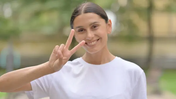 stock image Hispanic Woman Showing Victory Sign while Standing Outdoor