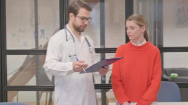 Doctor Discussing Medical Report with Patient in Clinic